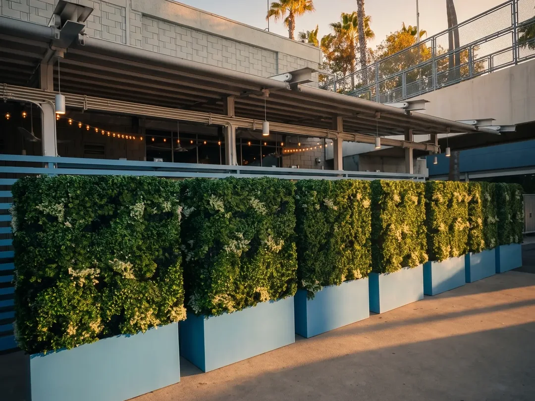 Freestanding artificial hedge planters on a restaurant patio